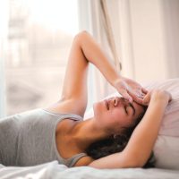 woman-in-gray-tank-top-lying-on-bed-3768582